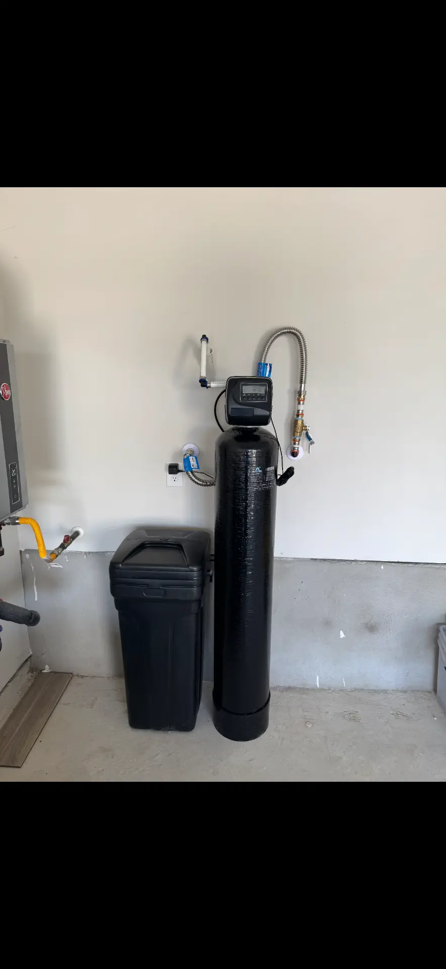 Water softener and brine tank against a garage wall